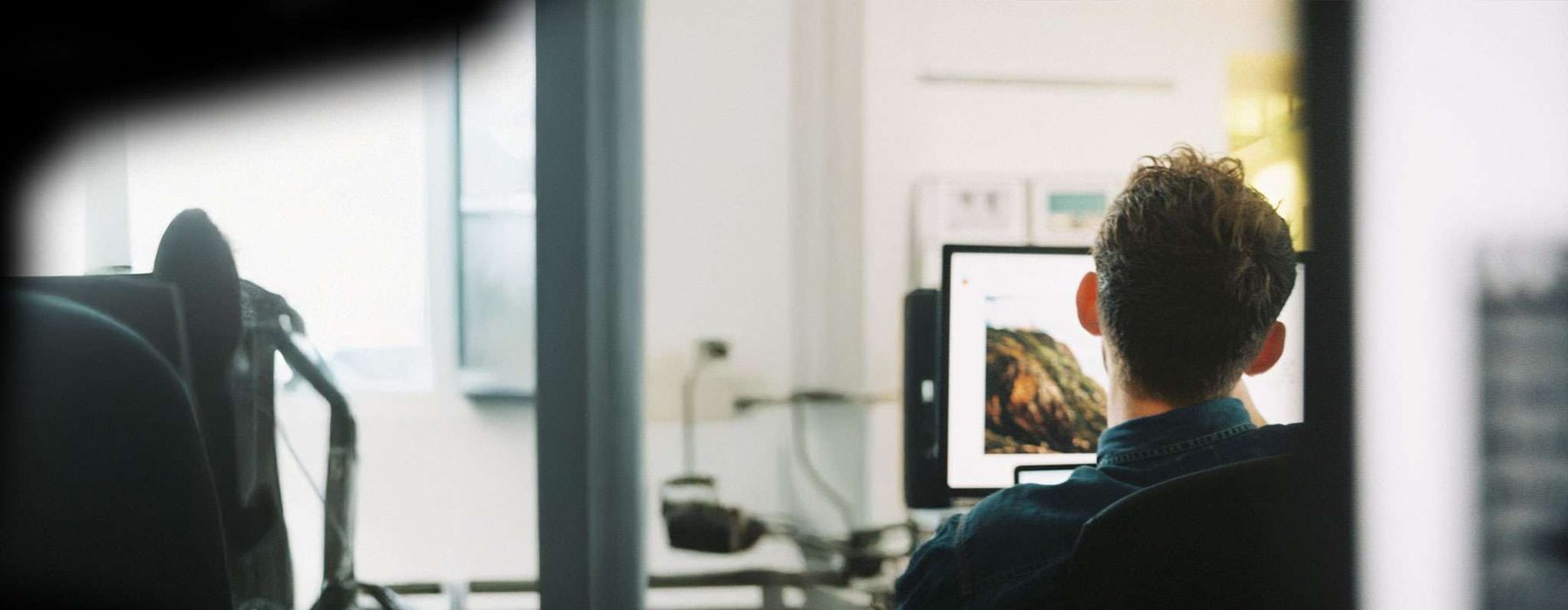 Designer at a monitor laying out a website for a Swansea business