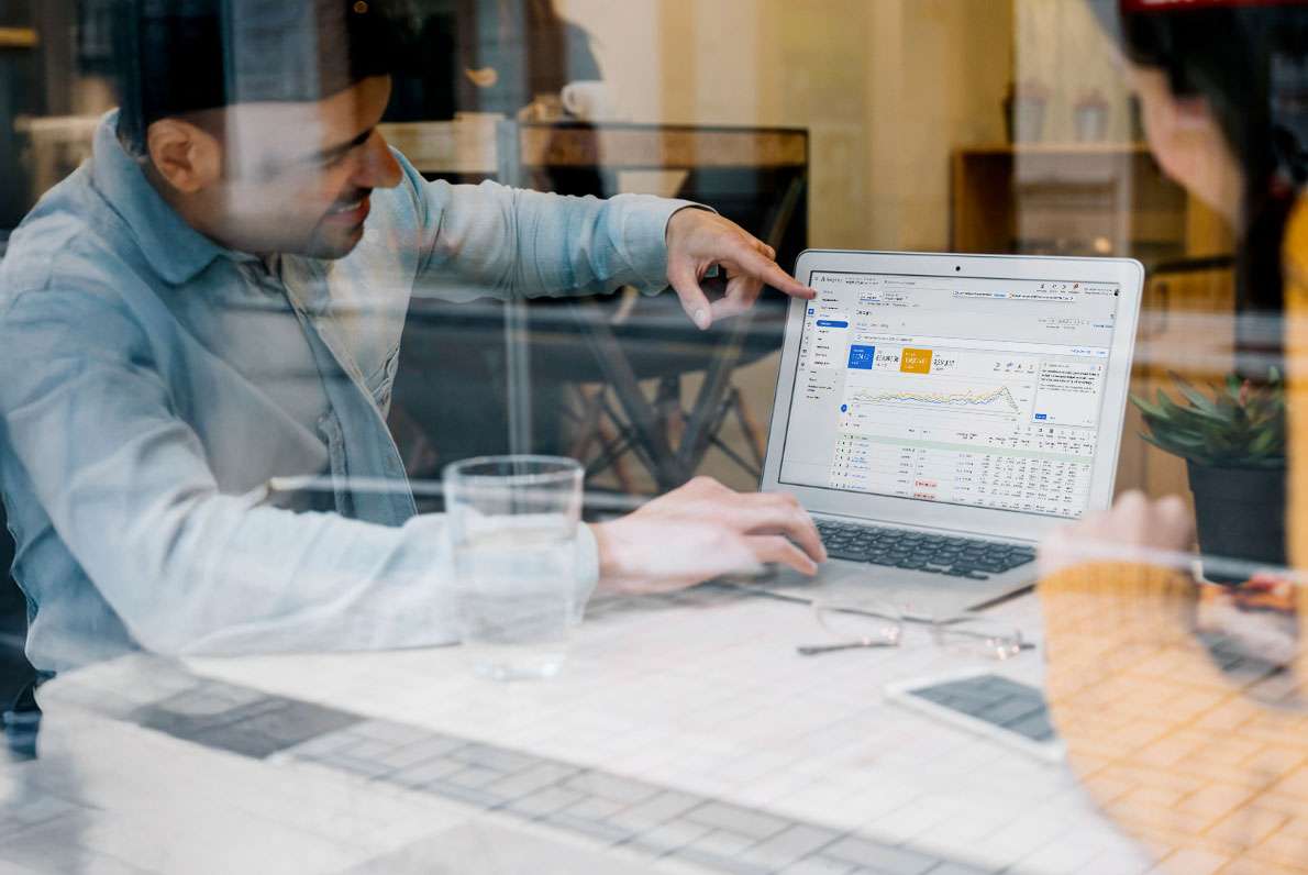 Two people reviewing Google Ads spend and results on a laptop