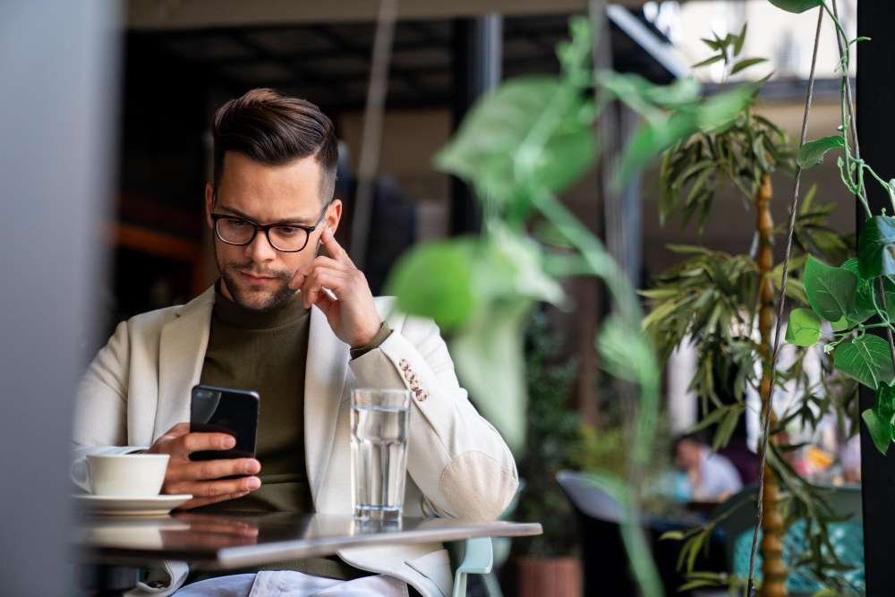 Swansea business owner checking his search results on his phone over a coffee