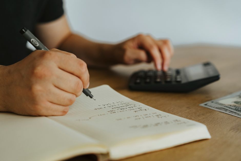 Calculator and notebook used to plan Black Friday discounts and margins