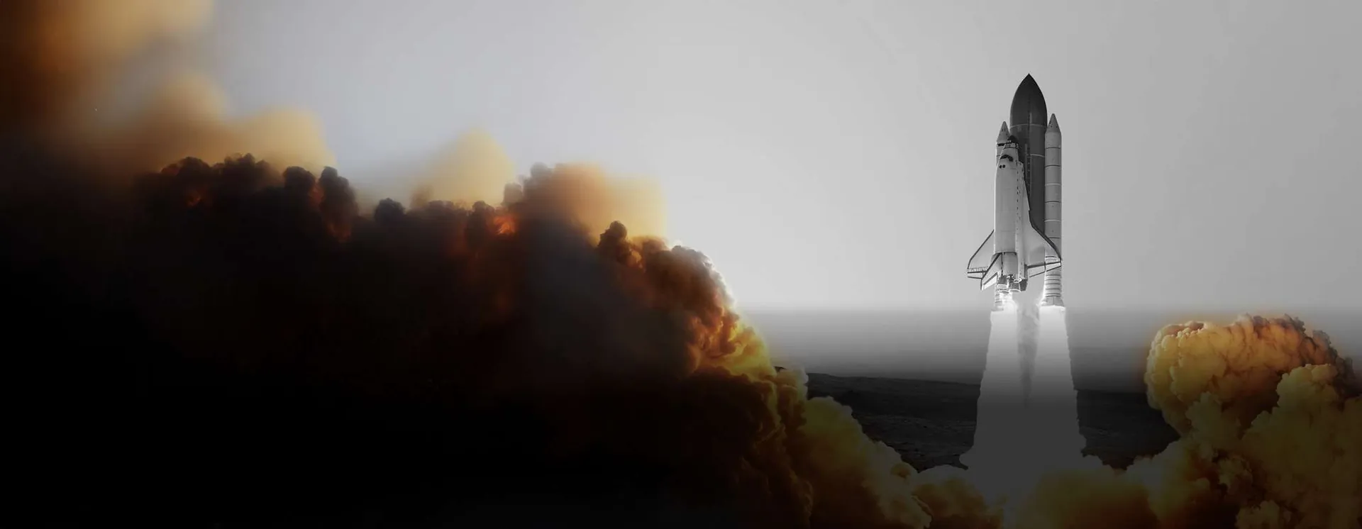 Space shuttle lifting off through clouds of smoke against a grey sky