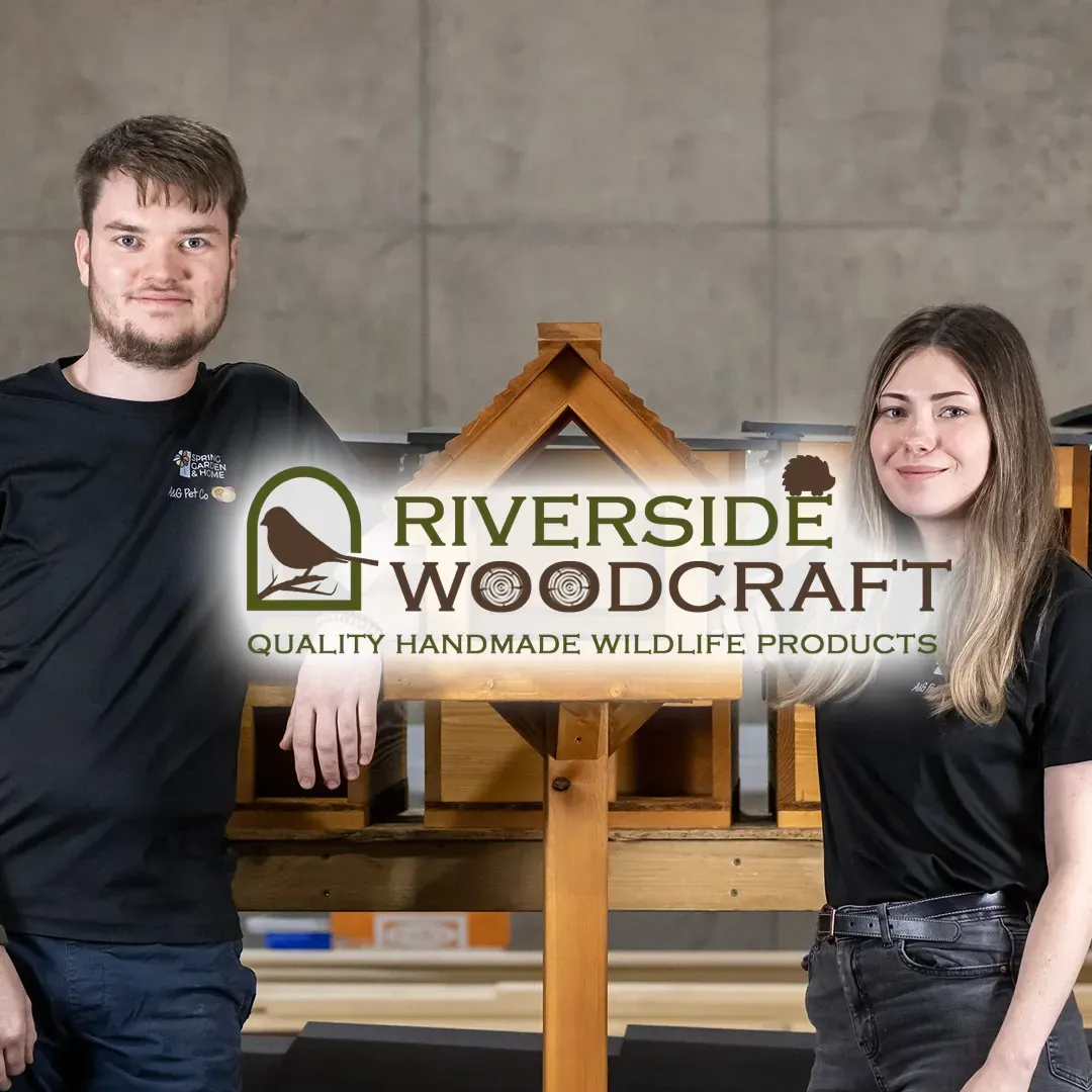 Riverside Woodcraft logo with the two owners standing beside a handmade wooden bird table