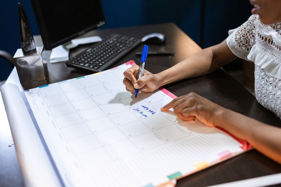 Small business owner planning a November sales calendar at a desk
